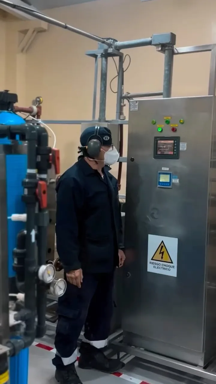 Técnico frente a un sistema de tratamiento de agua de la planta