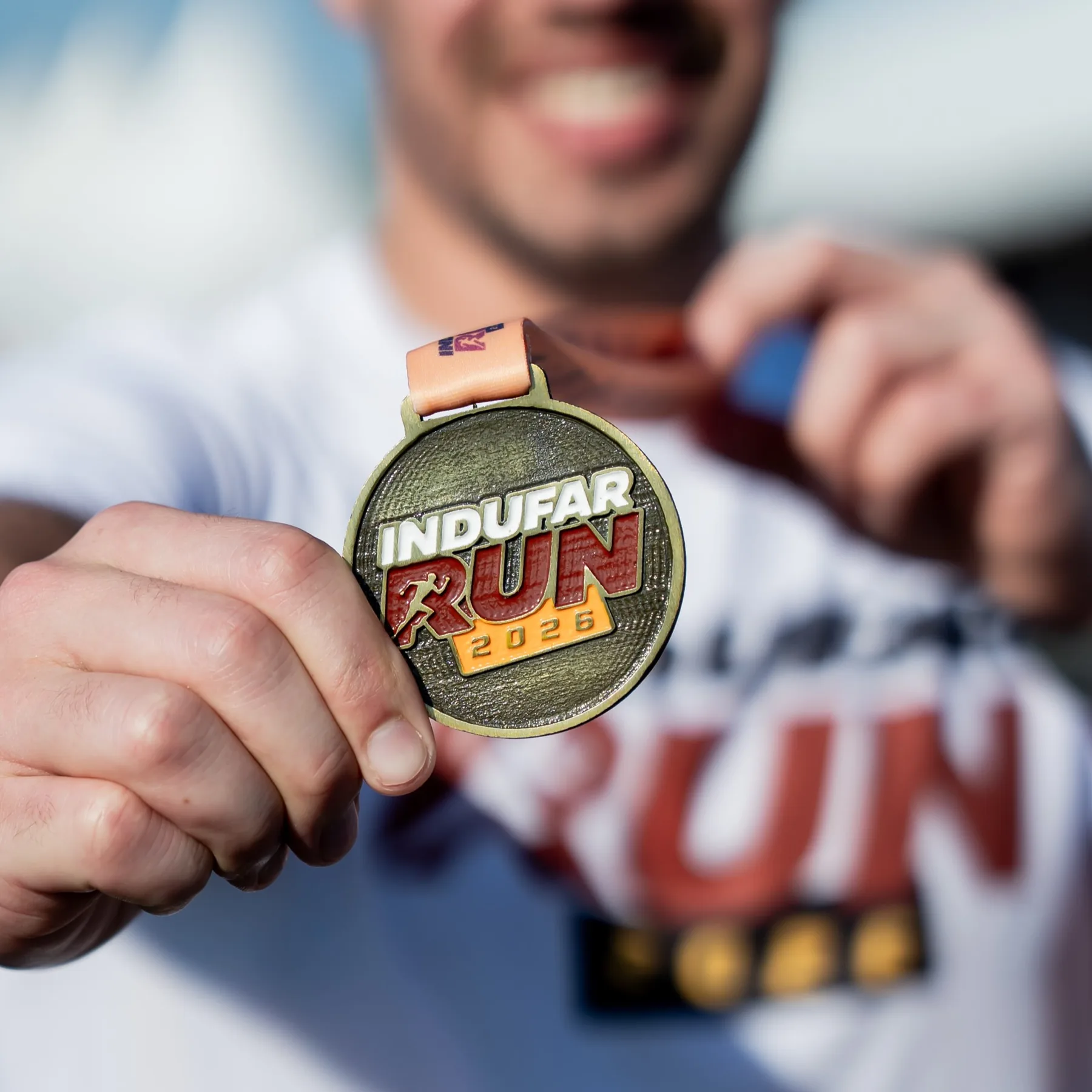 Corredor mostrando la medalla de Indufar Run 2026